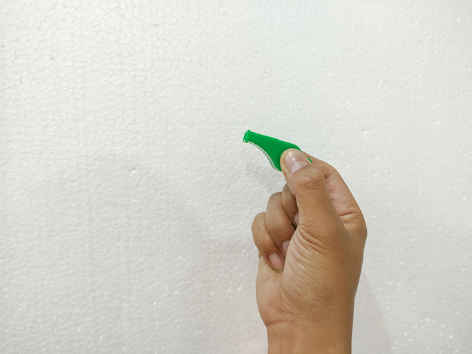 hand holding a green whistle